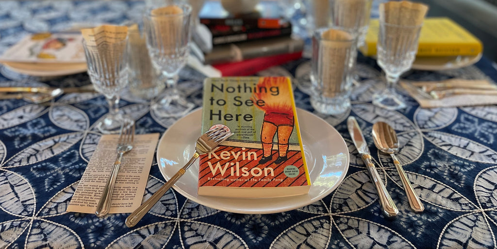 A table place setting with a book being served on the plate